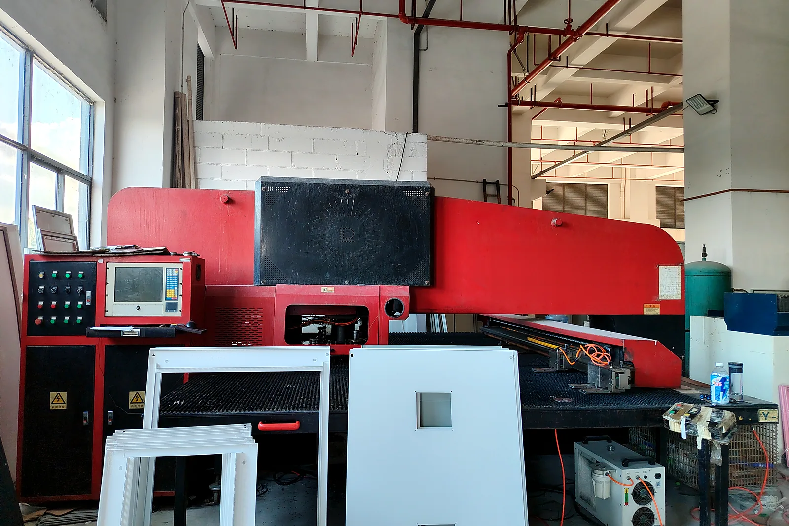 CNC-Stanzmaschine setzt Durchbrüche in ein Blechteil der Waschkabine